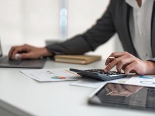 person using a calculator and laptop