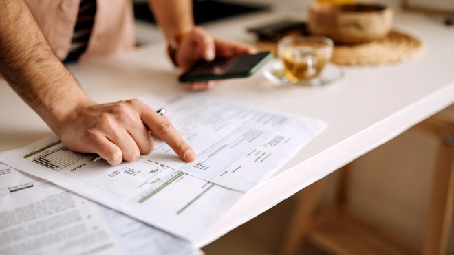 hands pointing at sheet and holding mobile