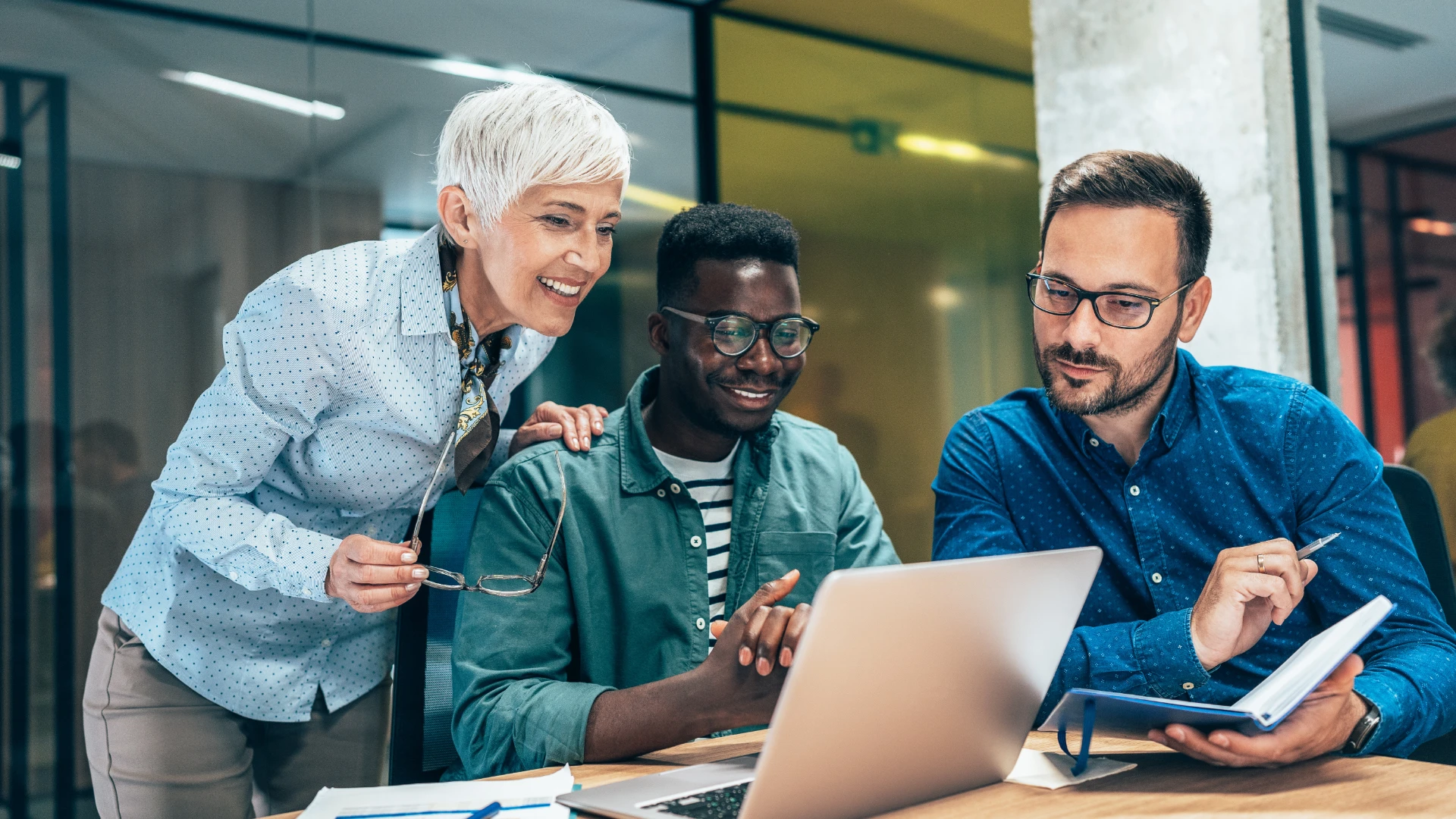 A team of 3 smiling in a meeting