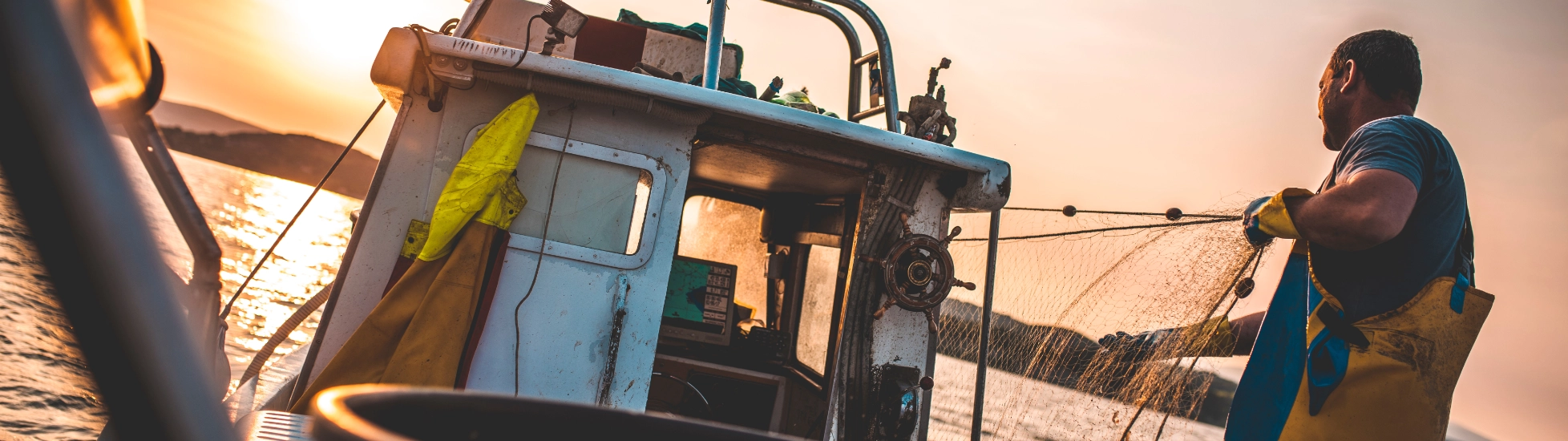 rear view of a fisherman on a boat preparing his nets